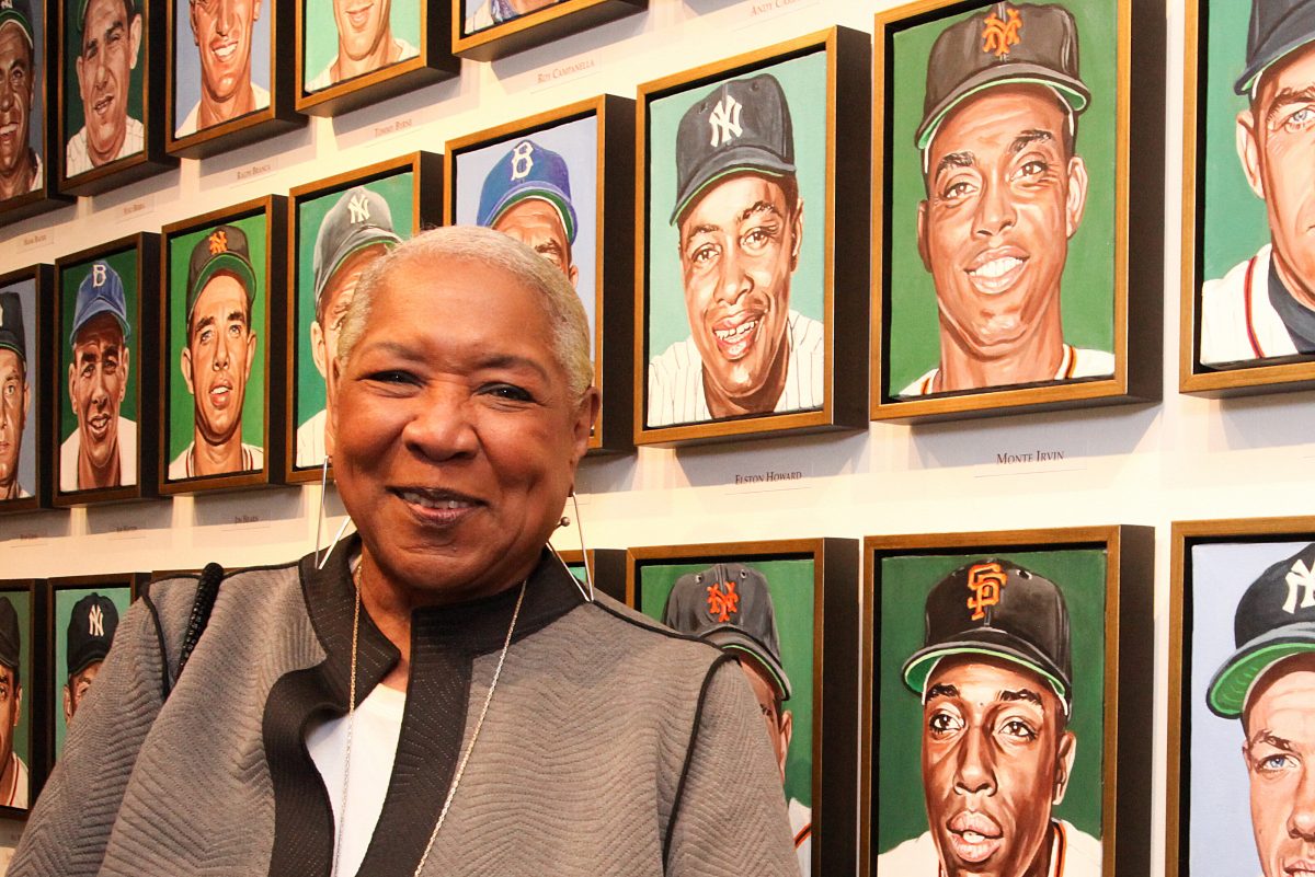 Pamela Irvin Fields with the portrait of her dad, Monte Irvin, as part of of Andy Jurinko's Golden Boys paintings