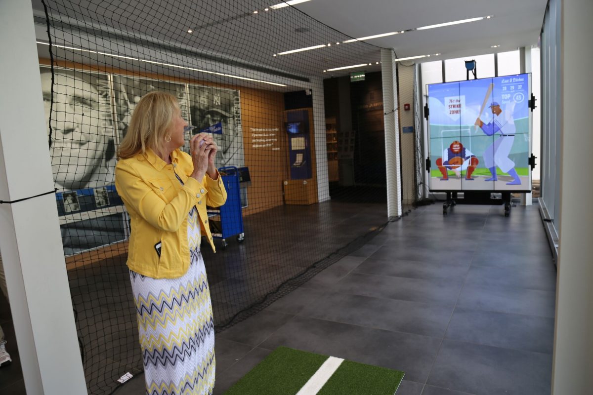 Adult woman about to pitch a baseball at the Pitch! exhibition