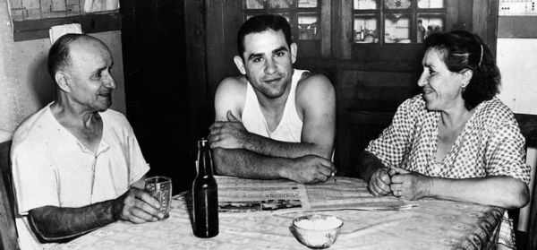 Yogi Berra at dinner table with his parents