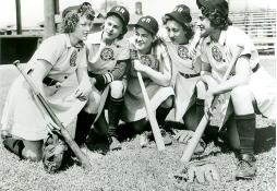Women huddled playing baseball