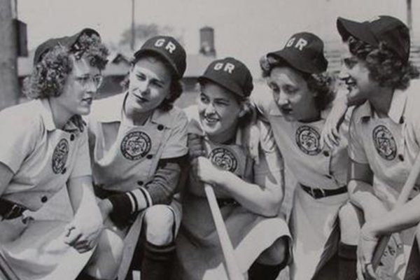 Women baseball players huddling.