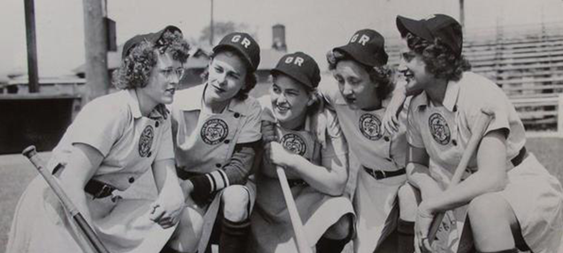Women baseball players huddling.