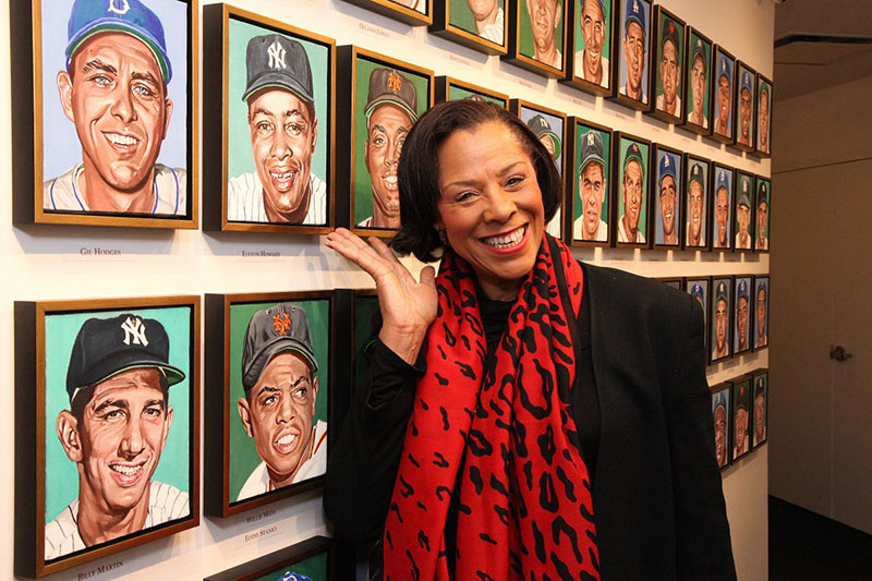 Cheryl Howard with the portrait of her dad, Elston Howard, as part of of Andy Jurinko's Golden Boys paintings