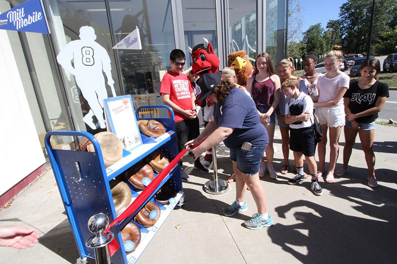 A group gathered around for the ribbon cutting opening of the Mitt Mobile