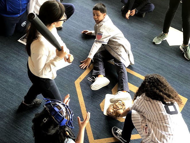 Students at the Museum mimicking various baseball player positions